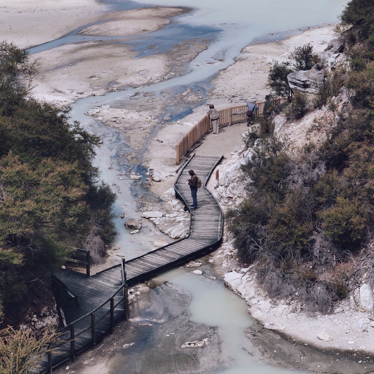 man on a bridge overlooking a river